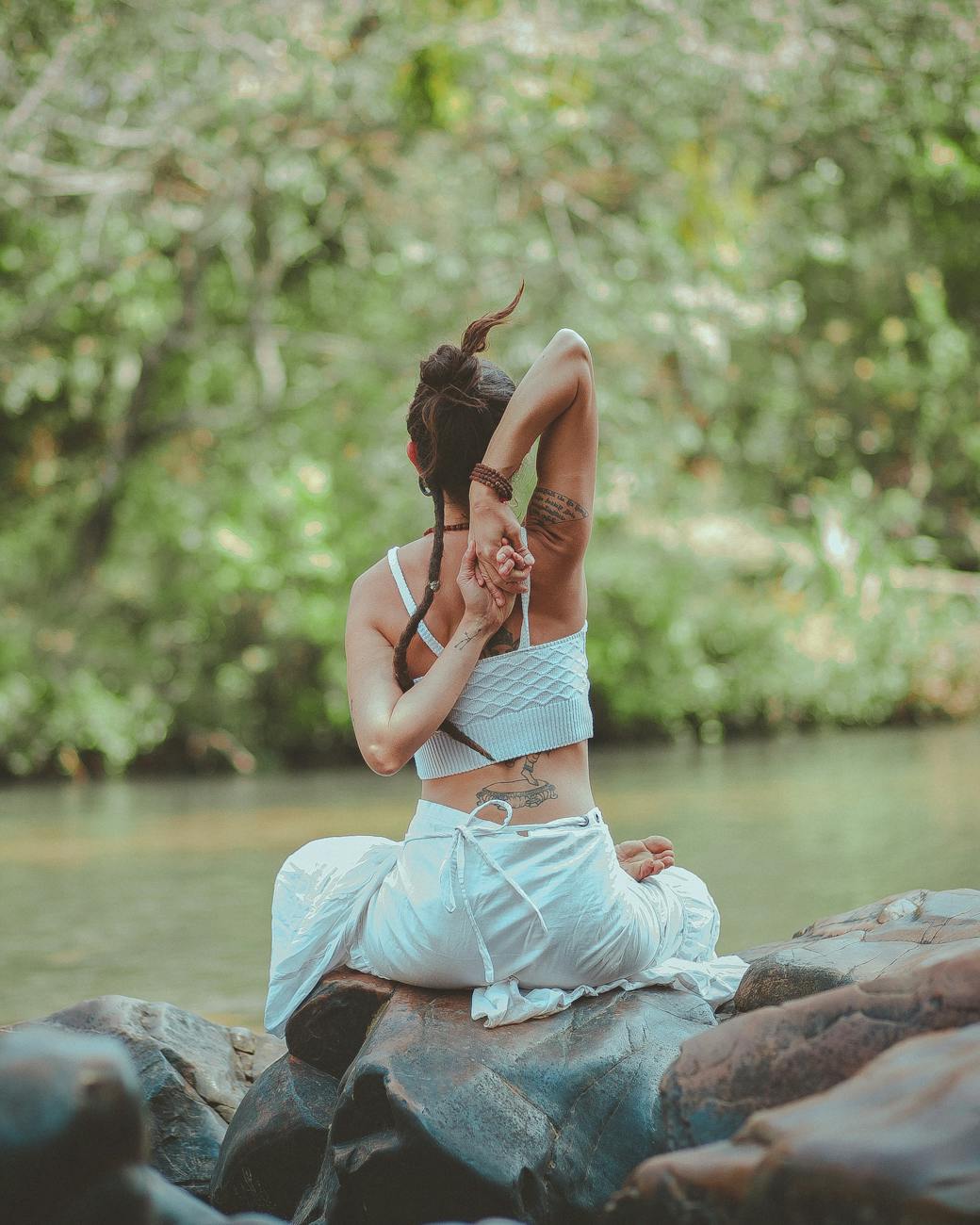 Mujer en postura de yoga junto al río